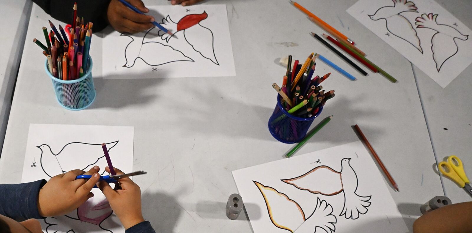 Children at a church in Turkey cutting out and coloring paper dove crafts from a Selah Seed lesson