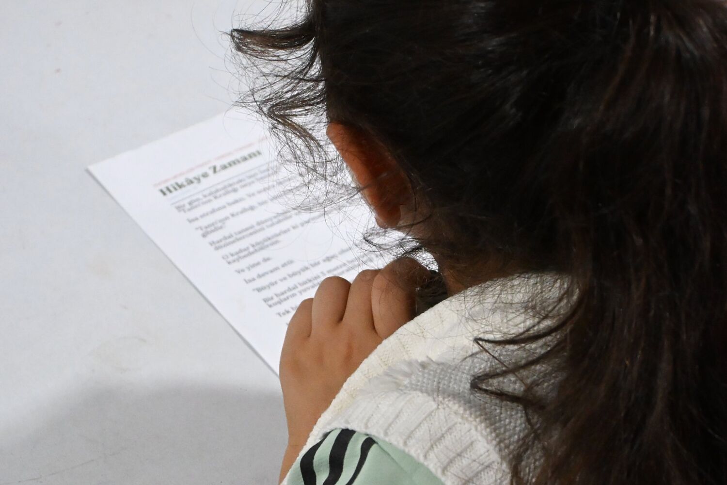 A girl at a church in Turkey reading the Story Time page of a Selah Seed lesson in Turkish